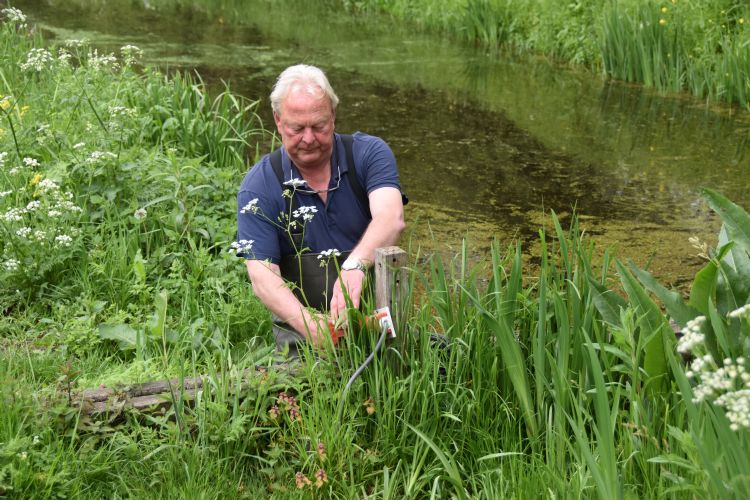 Cor Bavinck, hier in waadpak, beheert als enige de waterpompen.